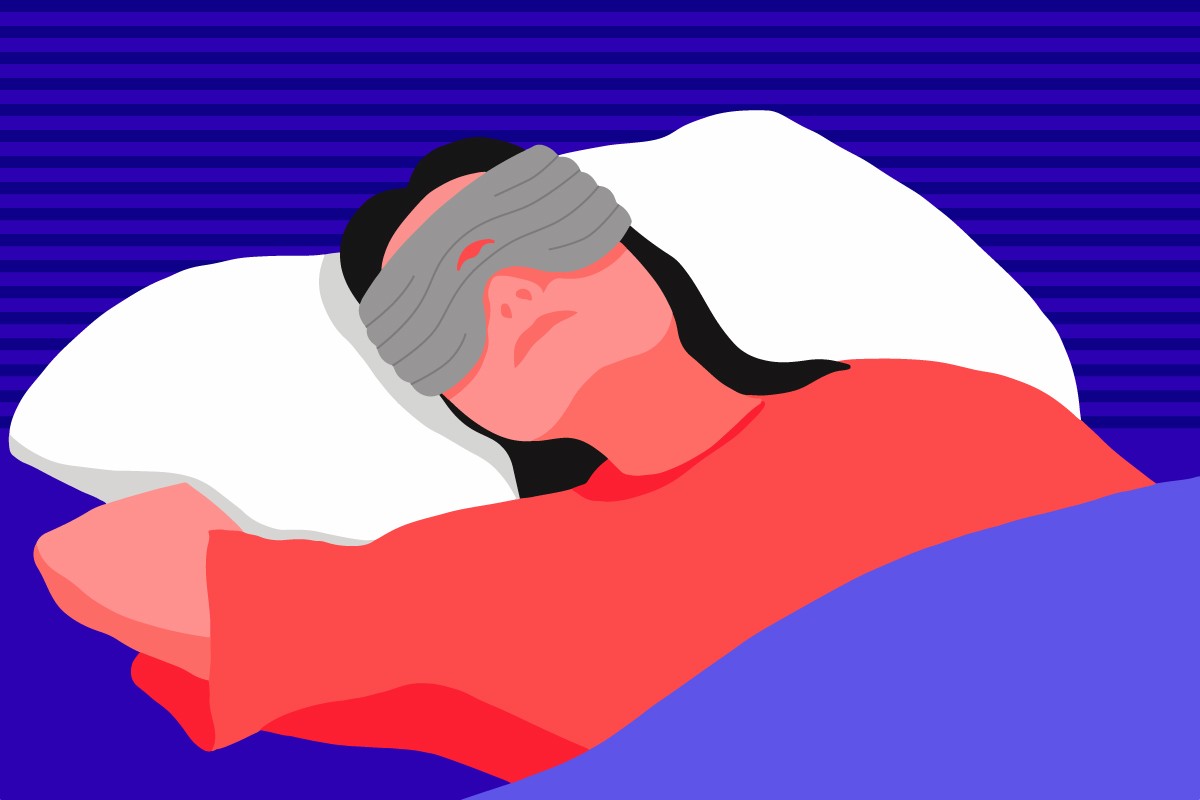 A girl lying in bed wearing a gray weighted sleep mask for headaches.