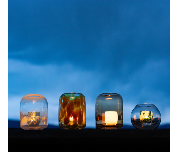 Glassybaby glass houses transparent large glass votive holders in various shapes and sizes outside under the sky