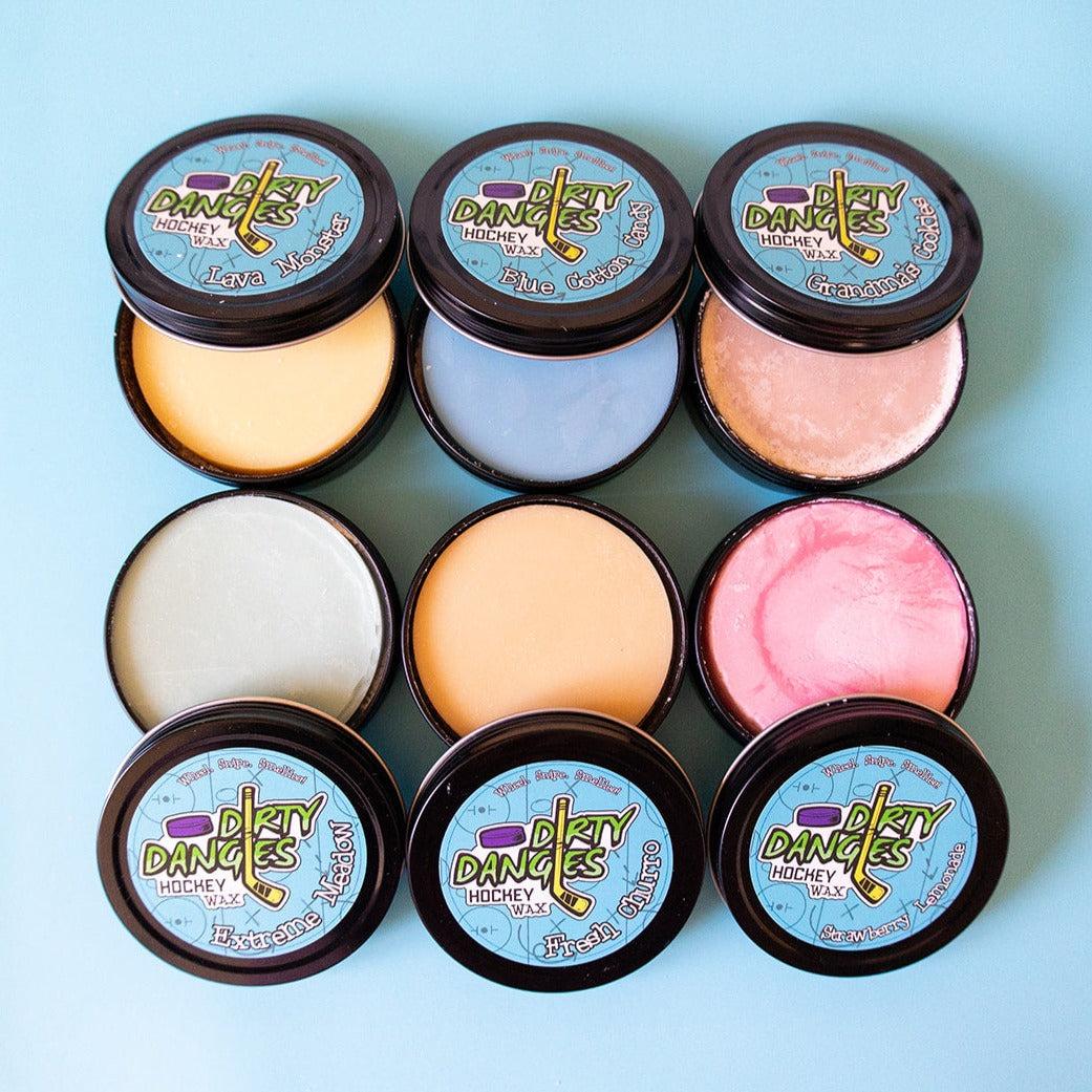 6 tins of dirty dangles hockey stick wax on a blue backgroun