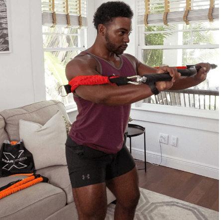 Man performing chest press using xbar complete home gym kit