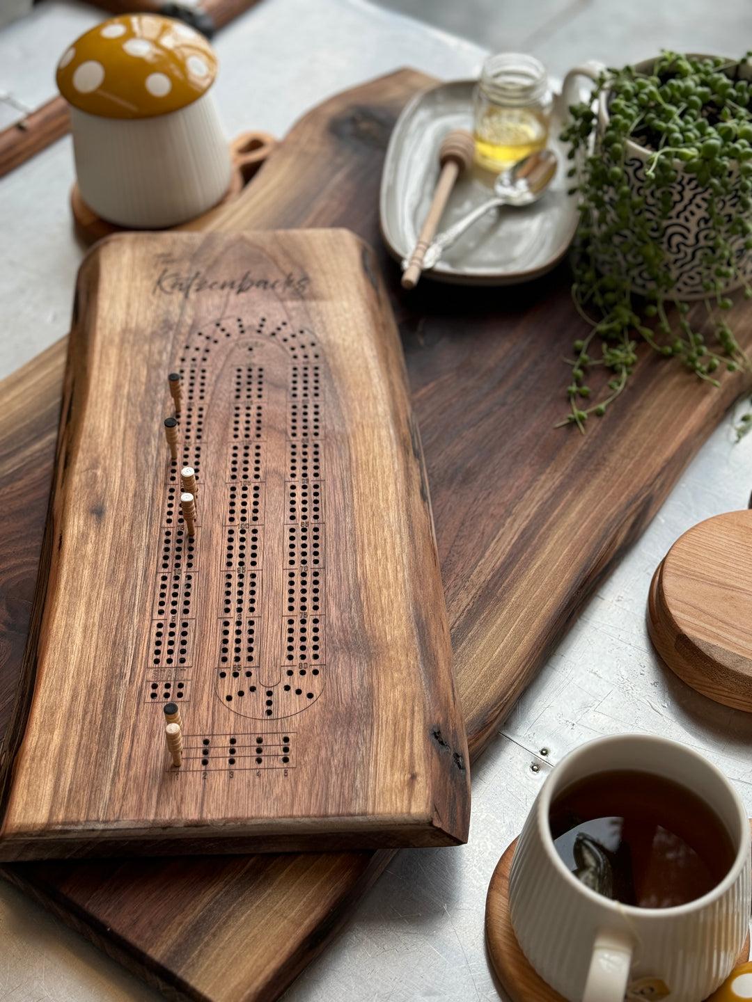 live edge cribbage board displayed on table with playing cards and coffee in home setting