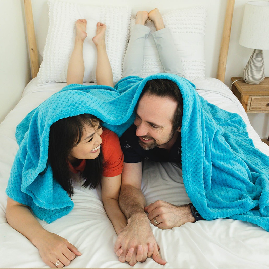 picture of a couple holding hands under a blue blanket
