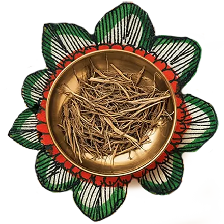 Vetiver roots in a golden color bowl, kept over an artwork of a flower