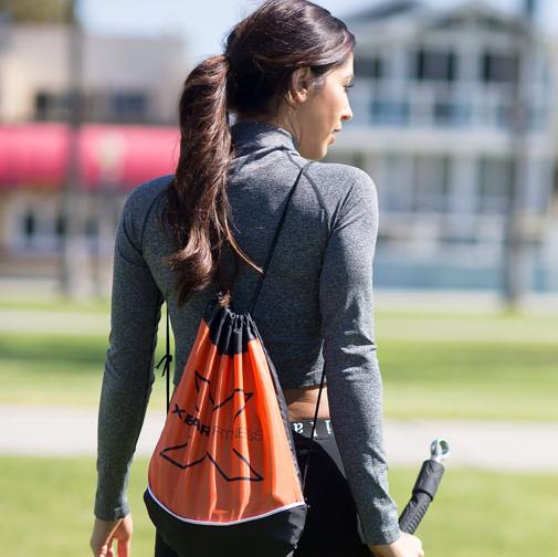 woman traveling using XBAR resistance bar safely during lower-body workout