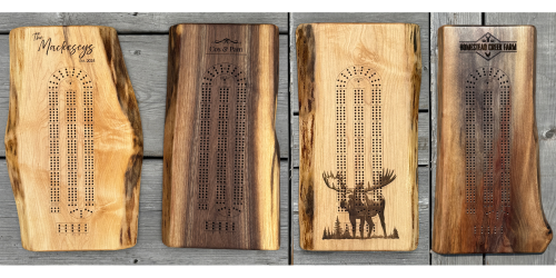 four engraved live edge cribbage boards with different engraving options.