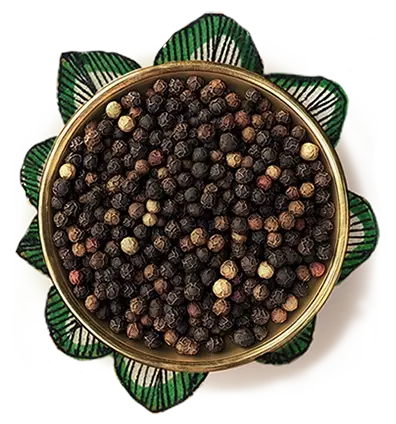 Black pepper in a golden color bowl, kept over an artwork of a flower