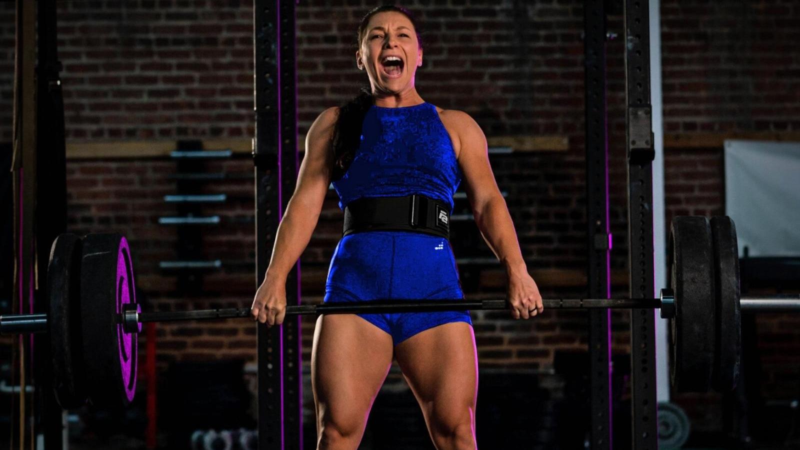 Woman squatting with a barbell wearing Fit Active Sports grey lever belt in a gym