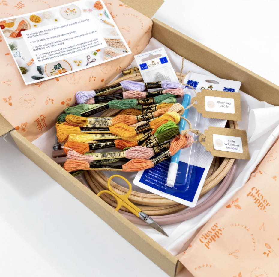 This image shows the Clever Poppy beginner modern embroidery bundle including thread packs, needles, scissors, fabric, a transfer pen, and Nurge + Rico Hoops, available for purchase from the Clever Poppy Shop.