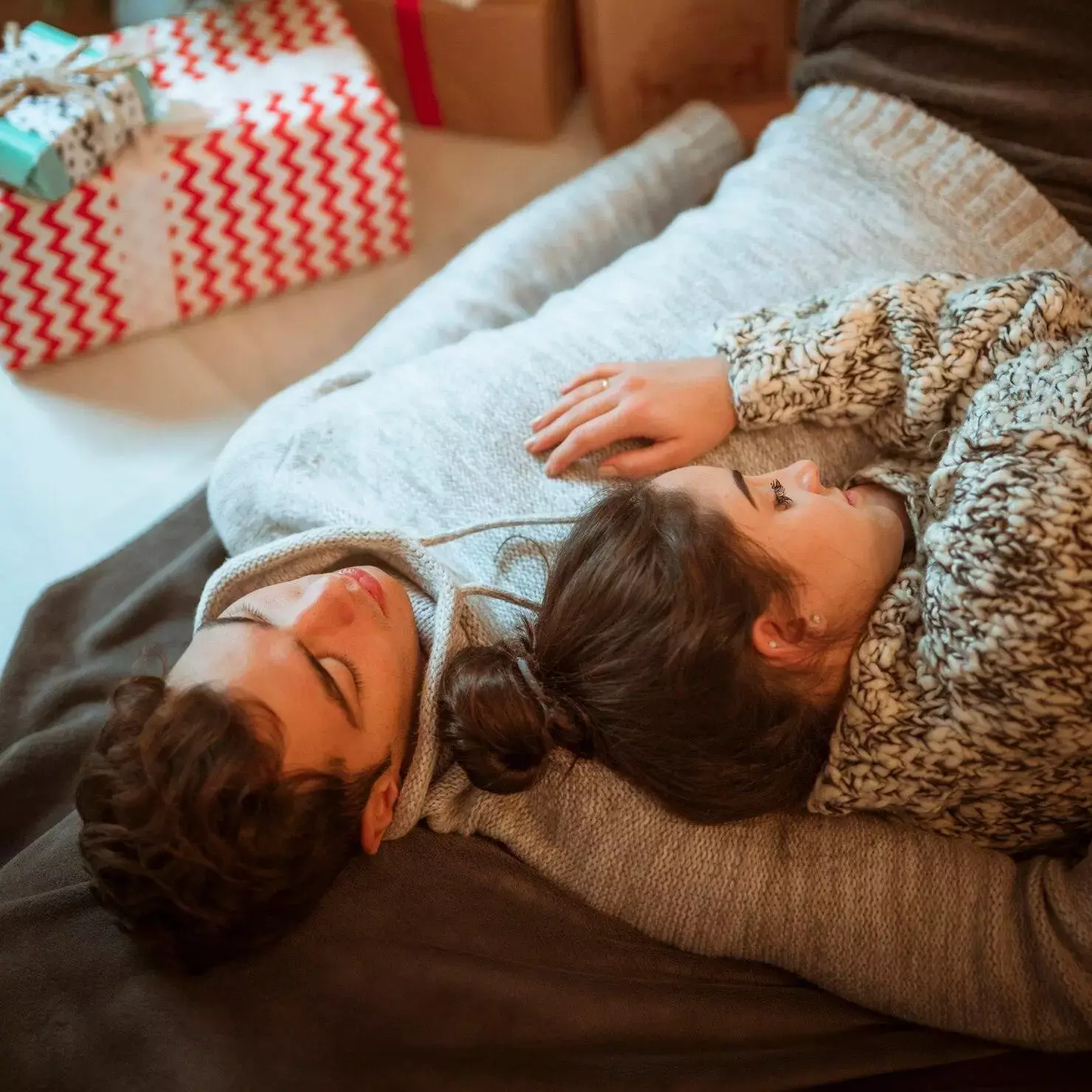 “Couple endormi paisiblement sur un canapé – image représentant les bienfaits d’un sommeil réparateur naturel”