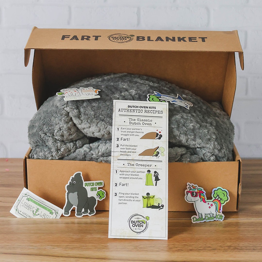 A gray dutch oven kit sits on a wood background with a recipe card and stickers. Fart Blanket