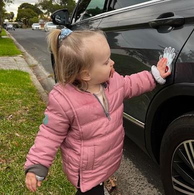 little girl using magnet to stand by car