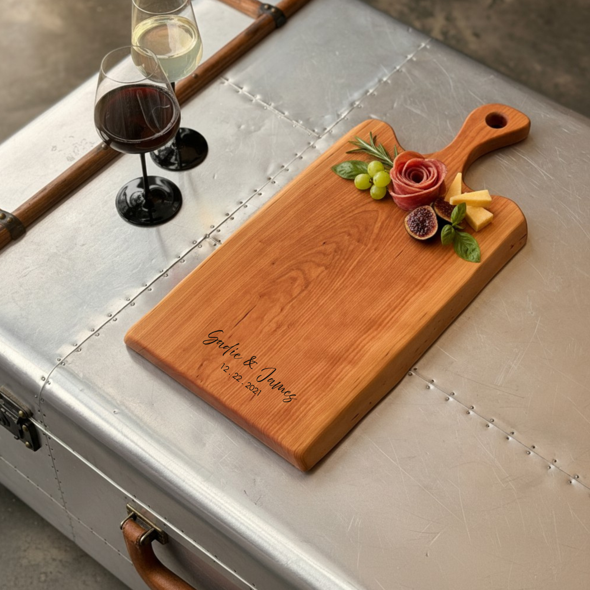 Personalized live edge maple cutting board with carved out handle. Styled with charcuterie, perfect for wedding and housewarming gift ideas