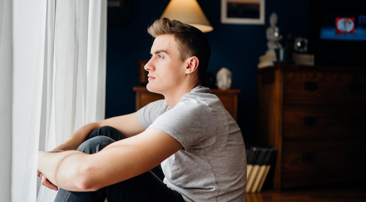 depressed man staring out window