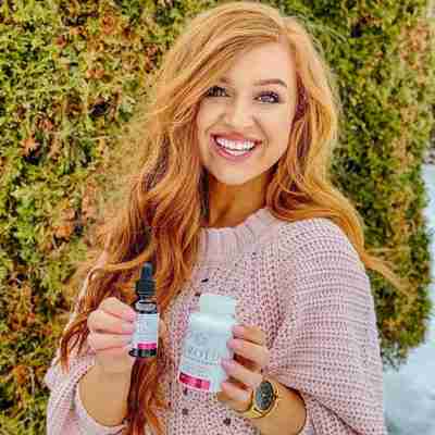 Model With Long Red Hair Holding Kerotin Products