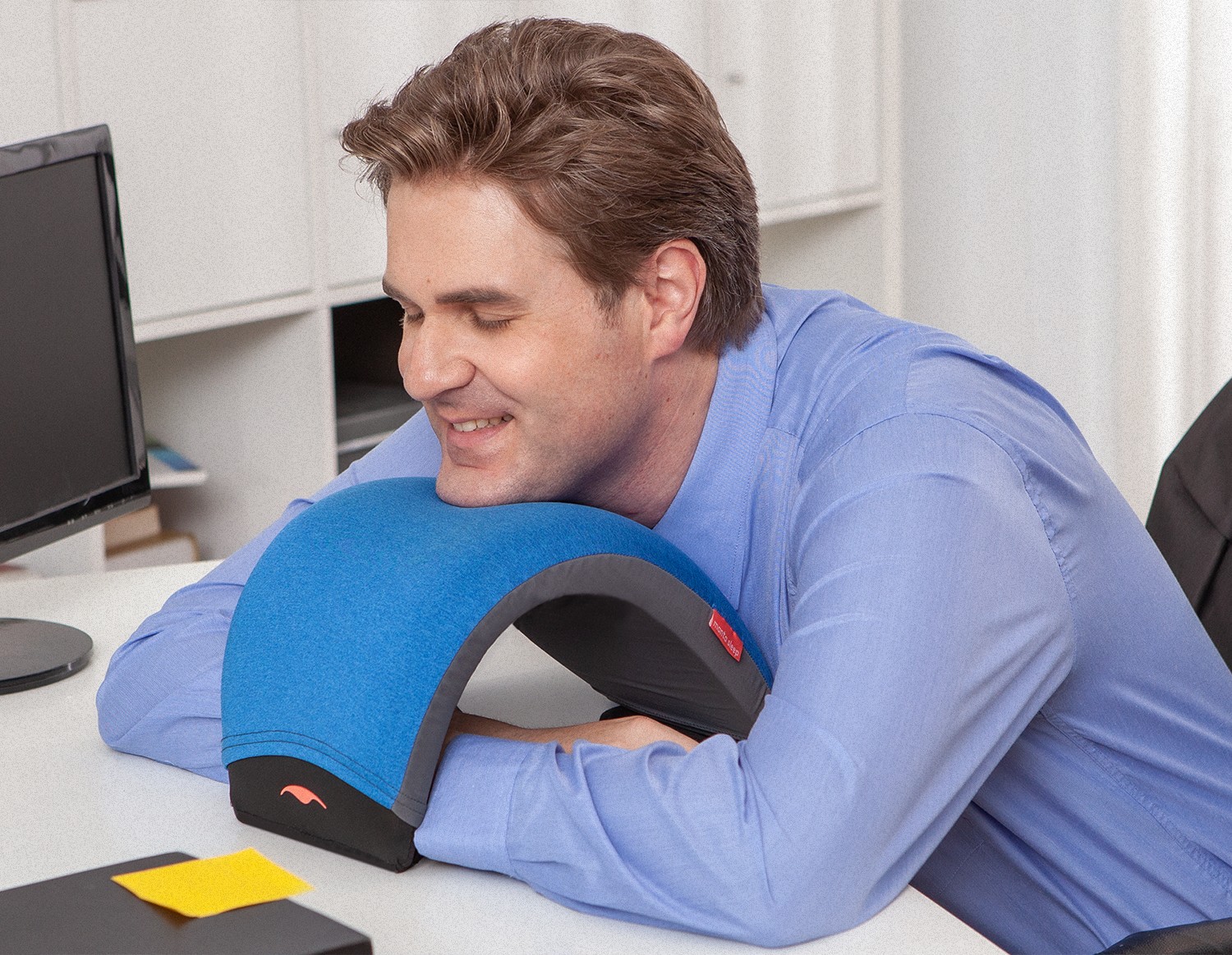 A man resting his chin on a nap pillow while taking a healthy daily nap.