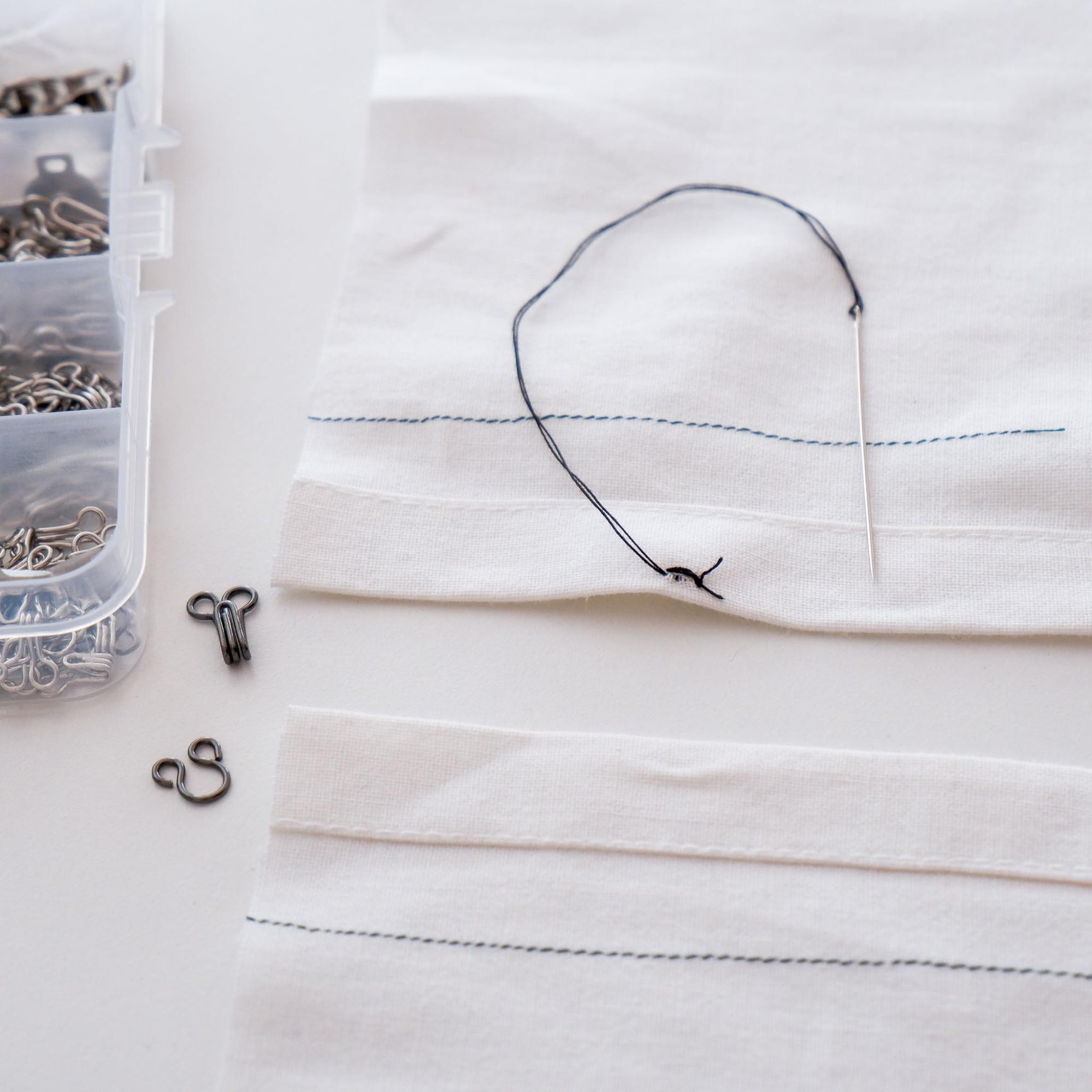 Hand stitch with a knot to sew on the hook of the hook and eye set