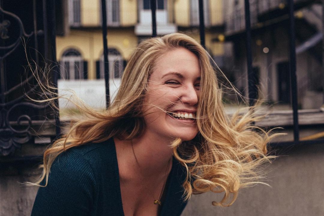 Woman laughing with city backdrop