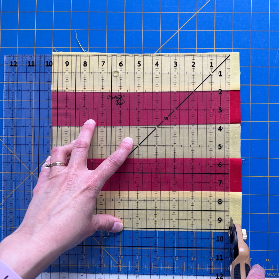 Trimming excess fabric on the right edge of the square-up ruler.