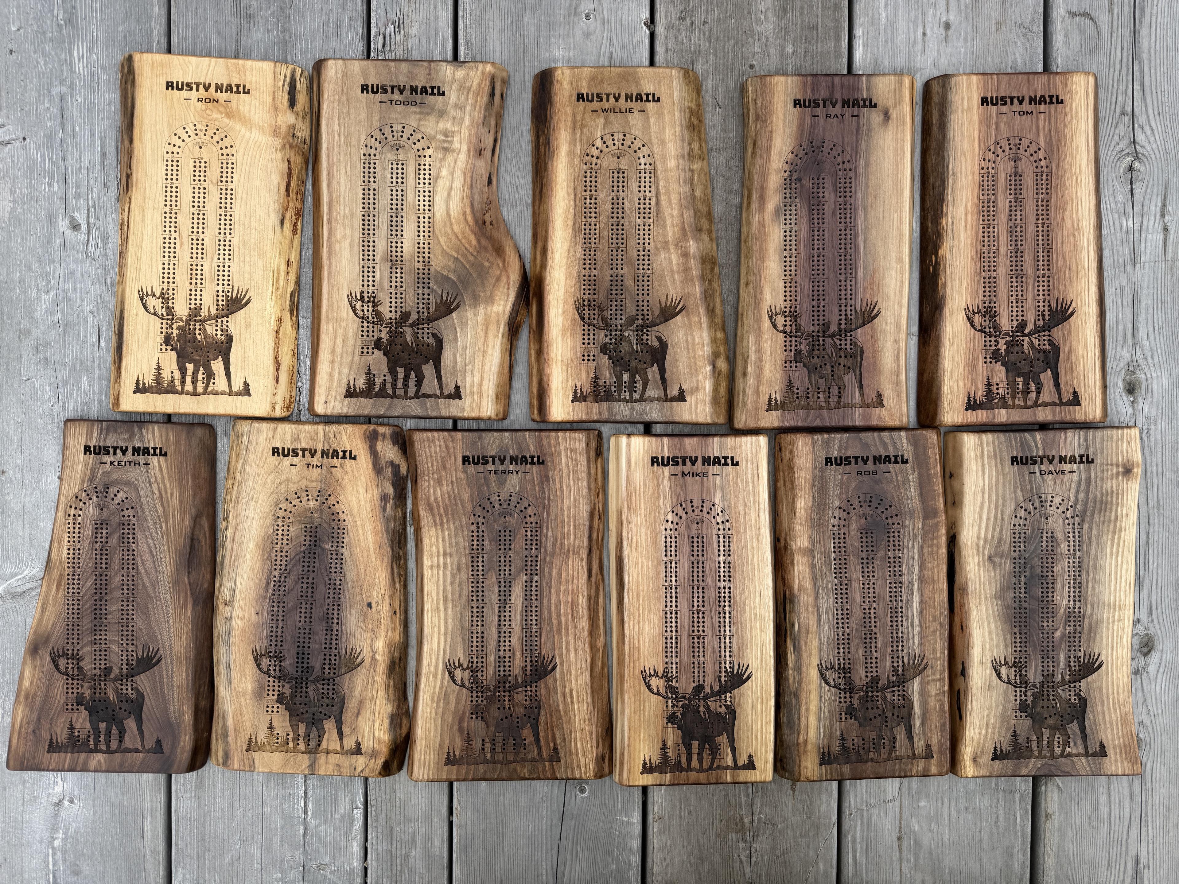 eleven live edge crib boards with a large moose and the names of each member of their hunting camp crew.