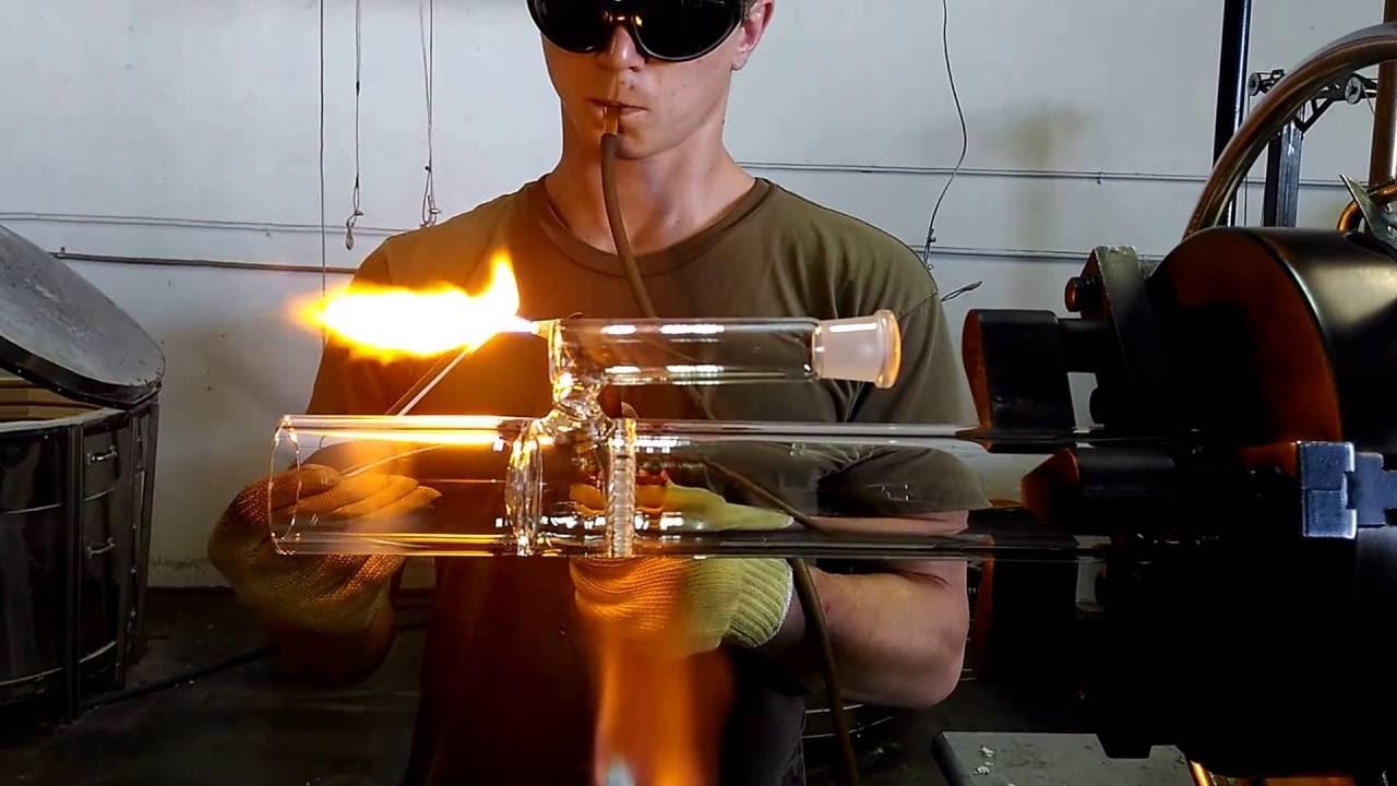 Glass artist blowing a classic honeycomb percolator onto the base of a glass water pipe on a lathe, demonstrating the difficulty of building a fixed disc perc.