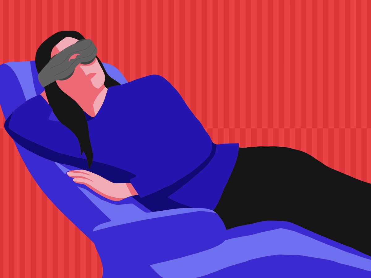 A girl relaxing on a recliner wearing a weighted mask from Manta Sleep.