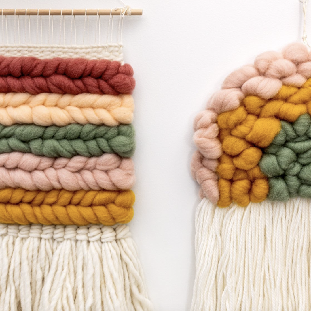 This image shows a beautiful weaving, Sorbet Crush, hanging on the wall, next to a woven rainbow.
