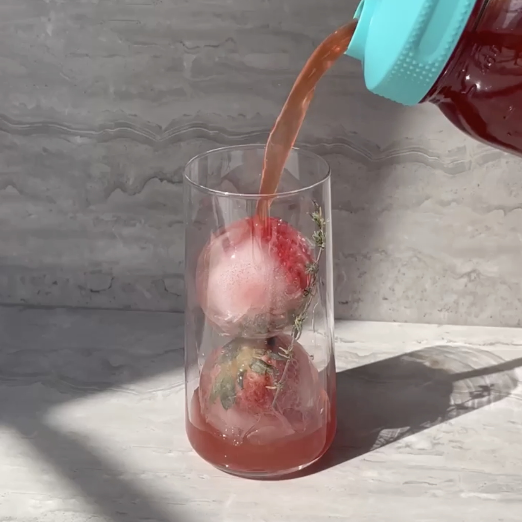 pouring cold brew over fruity tea-ice