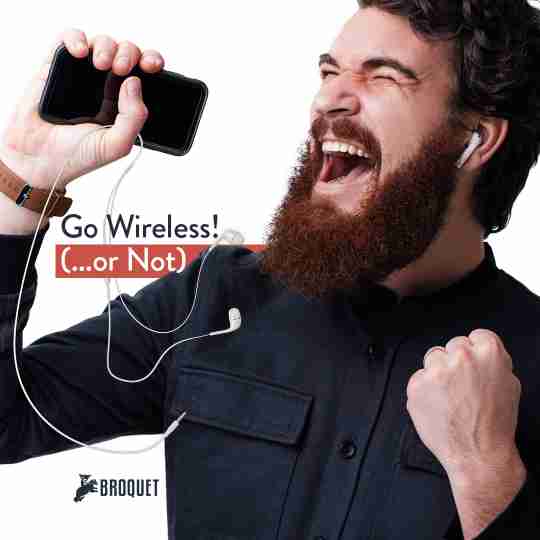 man screaming, one hand clenched, one hand holding a phone and earphones, broquet logo, text reads: Go Wireless! (or not)