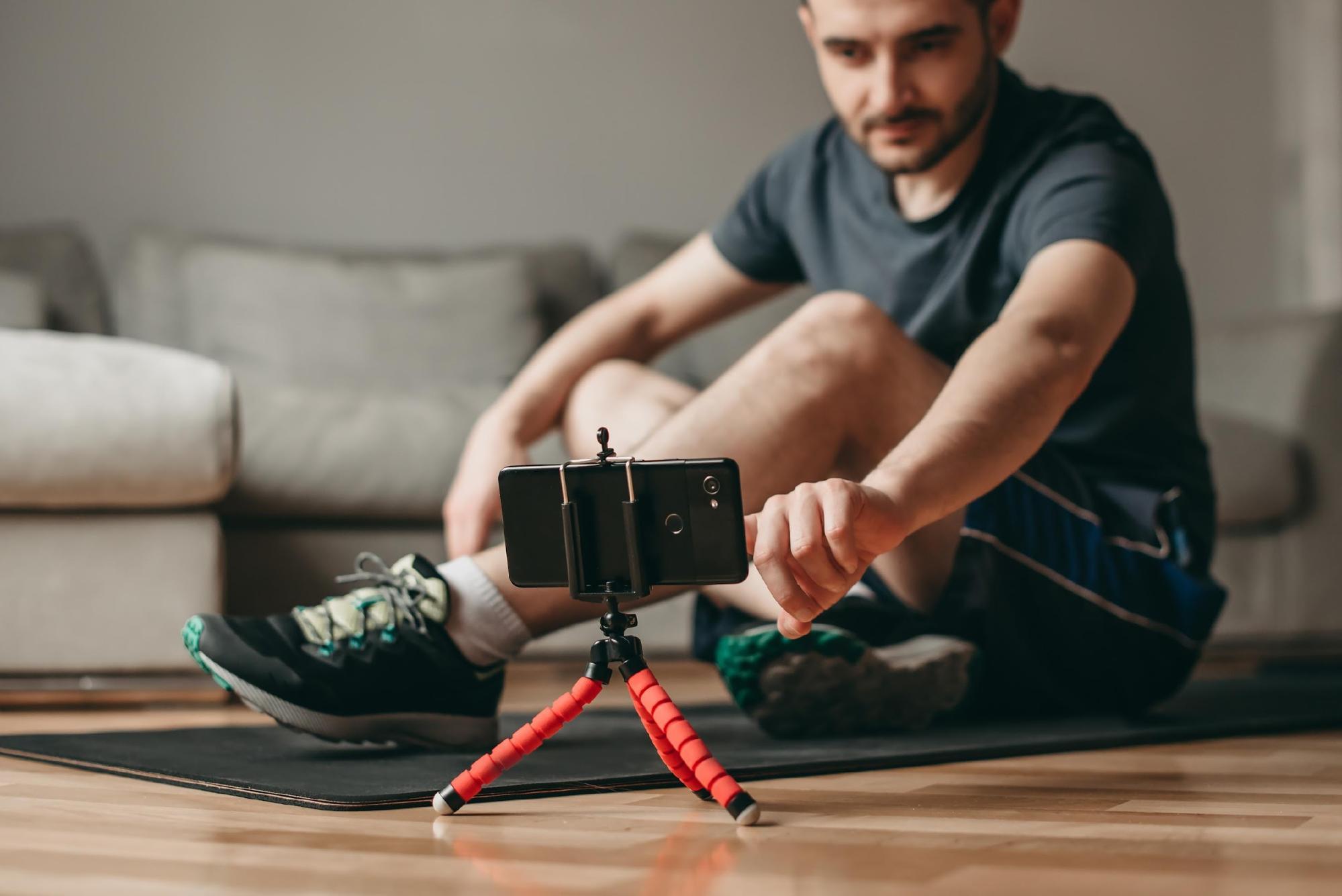 man workout at home using cellphone watch video