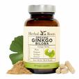 Bottle of Organic Herbal Roots Ginkgo Biloba with capsules and a small pile of ginkgo powder with a ginkgo leaf to the side of the bottle.
