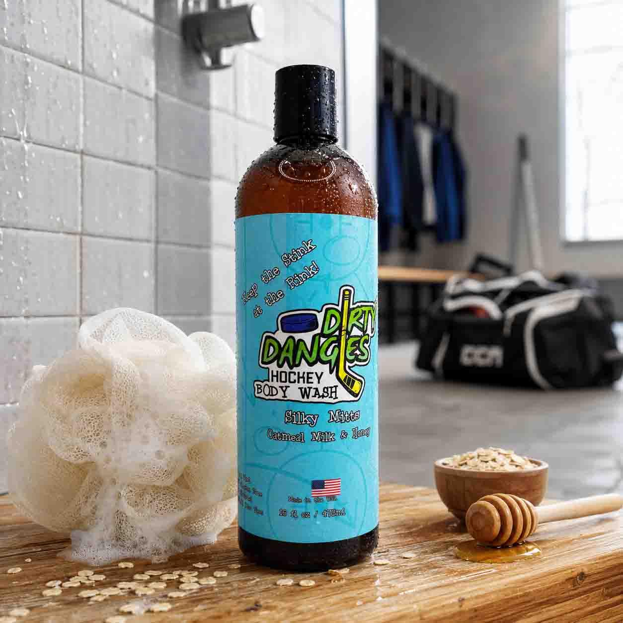 Silky Mitts oatmeal milk and honey hockey Body Wash on a wooden bench inside a hockey locker room with oatmeal, honey and a white loofah