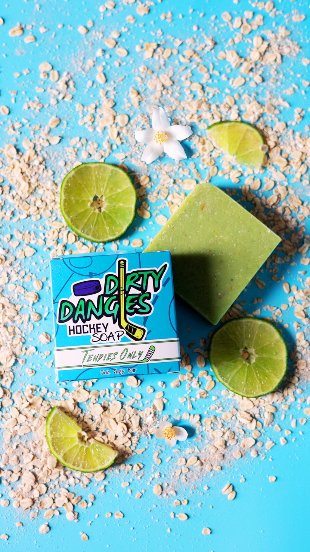 A green bar of dirty dangles hockey soap on a blue background with oats and limes
