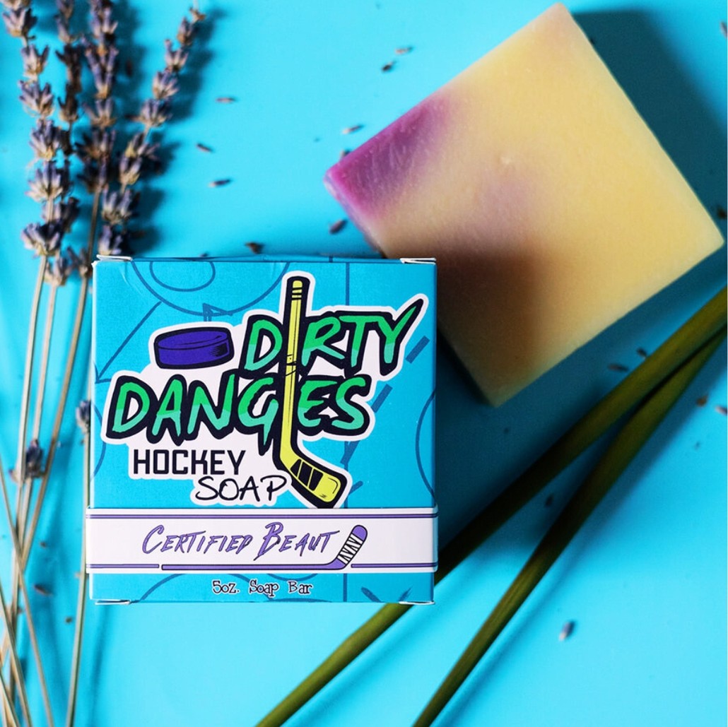 A purple and yellow bar of dirty dangles hockey soap on a lemongrass.