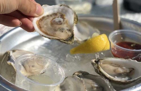 Person Eating Oysters Lemon Red Sauce