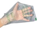 A hand holding a compostable dog poo bag