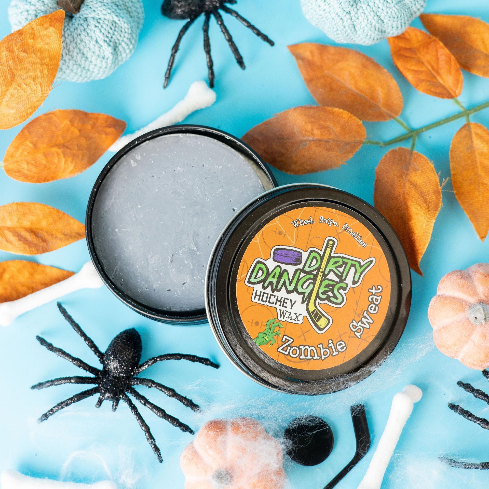 zombie sweat pumpkin spice scented hockey stick wax on a blue background with spiders and fall decor