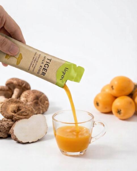 Hand pouring Tigrox liquid supplement into a glass