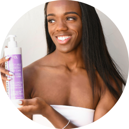 young woman smiling and holding up a bottle of Noche's Fresh Collagen Body Milk