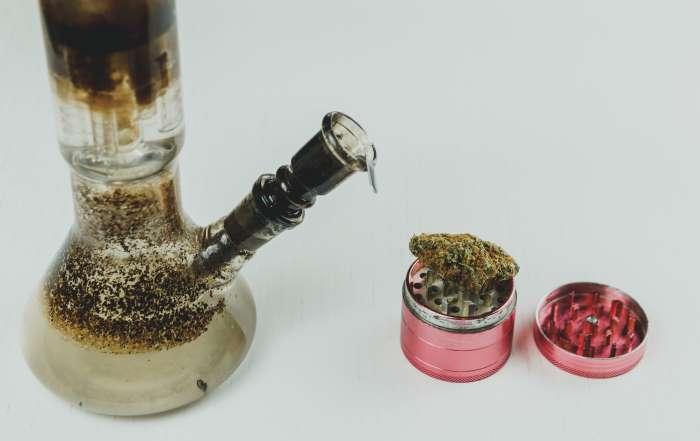 "A dirty, moldy glass bong from a traditional single-piece brand, showing heavy resin and organic buildup in hard-to-reach chambers. This image illustrates the difficulty of cleaning fixed-glass water pipes compared to Prism’s unique modular functionality, which allows for easy disassembly and thorough sanitation of every component."