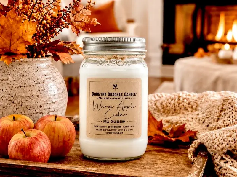 warm apple cider large soy candle fall scene with apples, leaves, and fireplace
