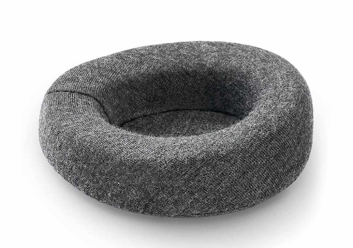 A single convex eye cup for a sleep mask covered in dark gray breathable fabric.