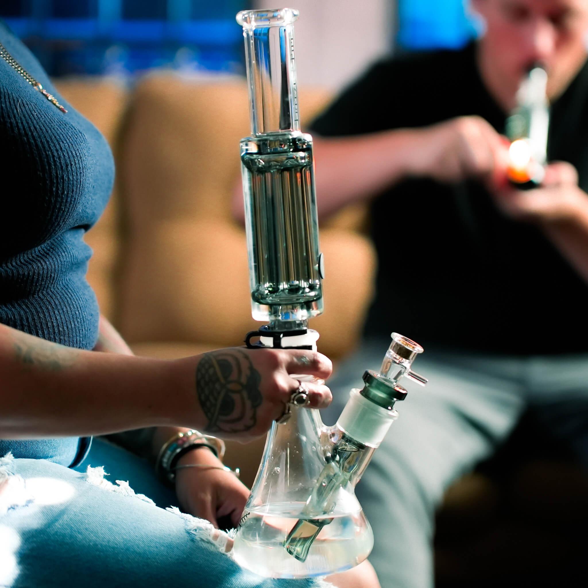 woman holding freeze pipe beaker ultimate on couch