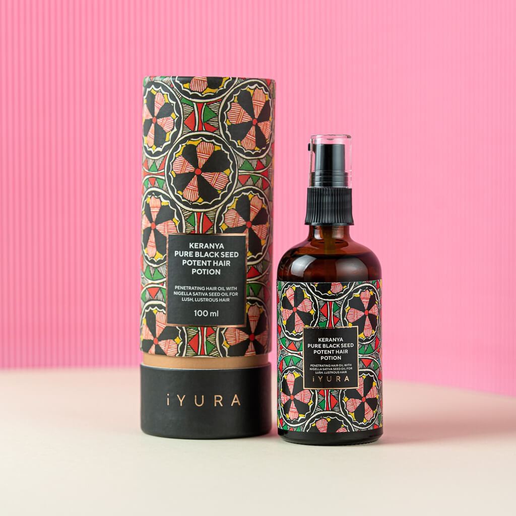 A bottle of Keranya Pure Black Seed oil placed next to its packaging