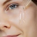 Woman applying Poreslay face serum on a clean, damp face