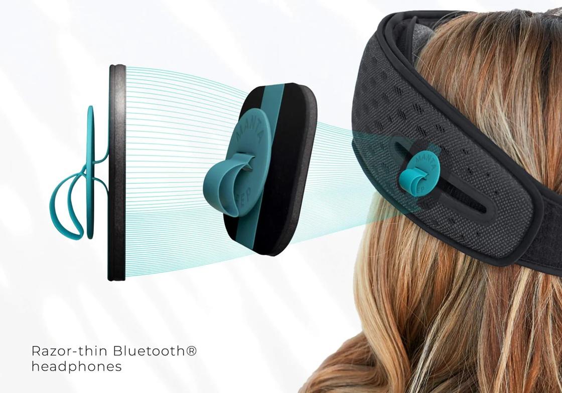 Square Bluetooth speakers with rounded corners and blue tabs beside the strap of a Bluetooth sleep mask.