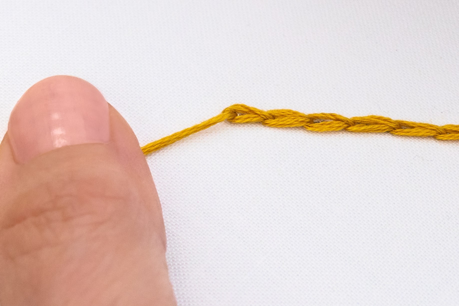 A hand holds a chain of chain stitch.