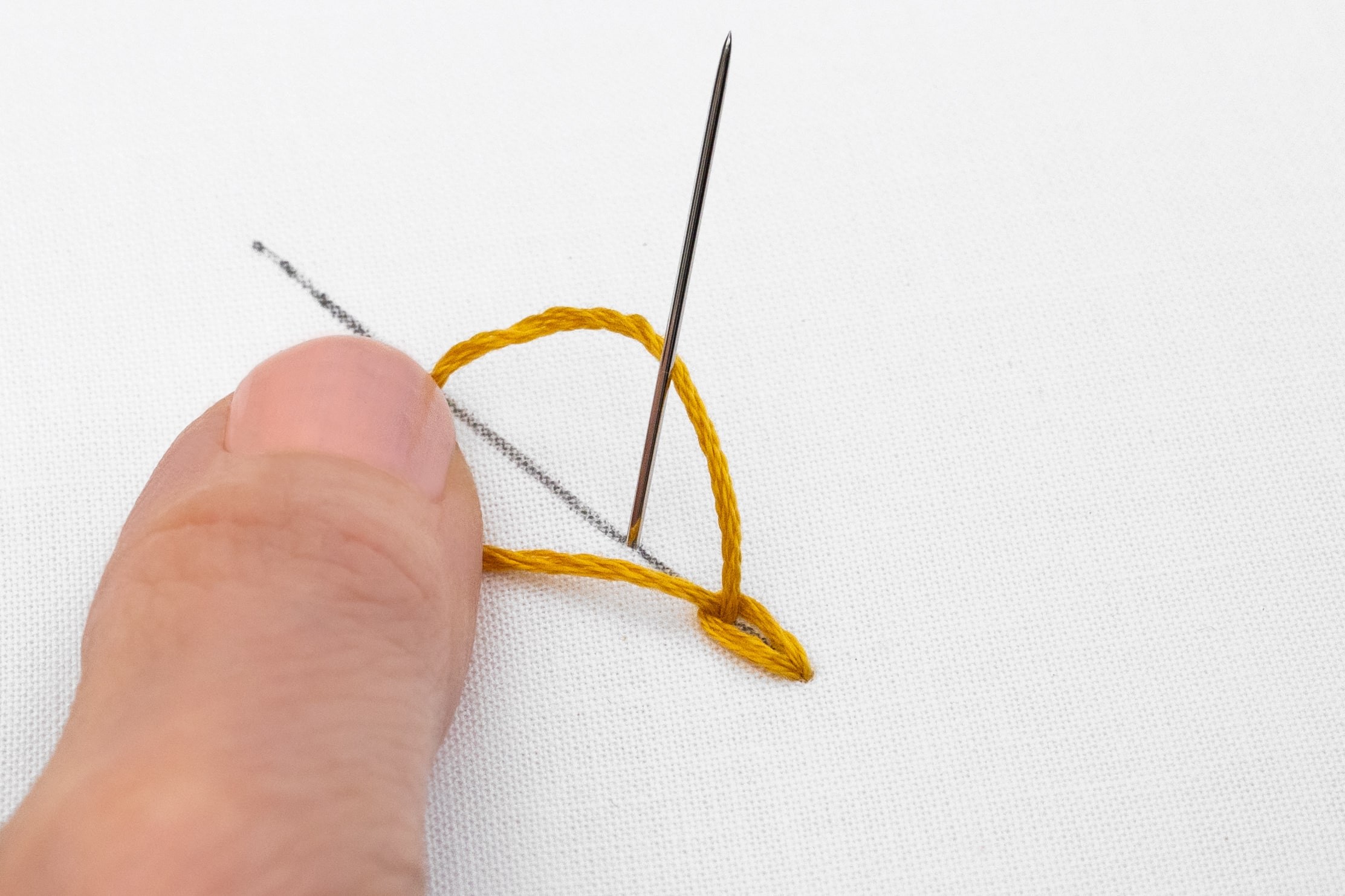 A needle comes up between a second loop.