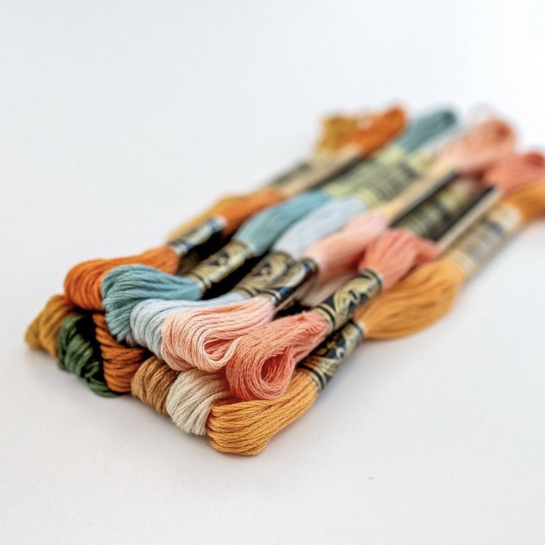 This is an image of DMC Threads stacked on top of each other, available for purchase from the Clever Poppy Shop.