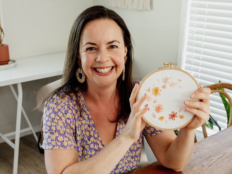 Julie from Clever Poppy holds up her Free Petal Breeze modern embroidery creation.