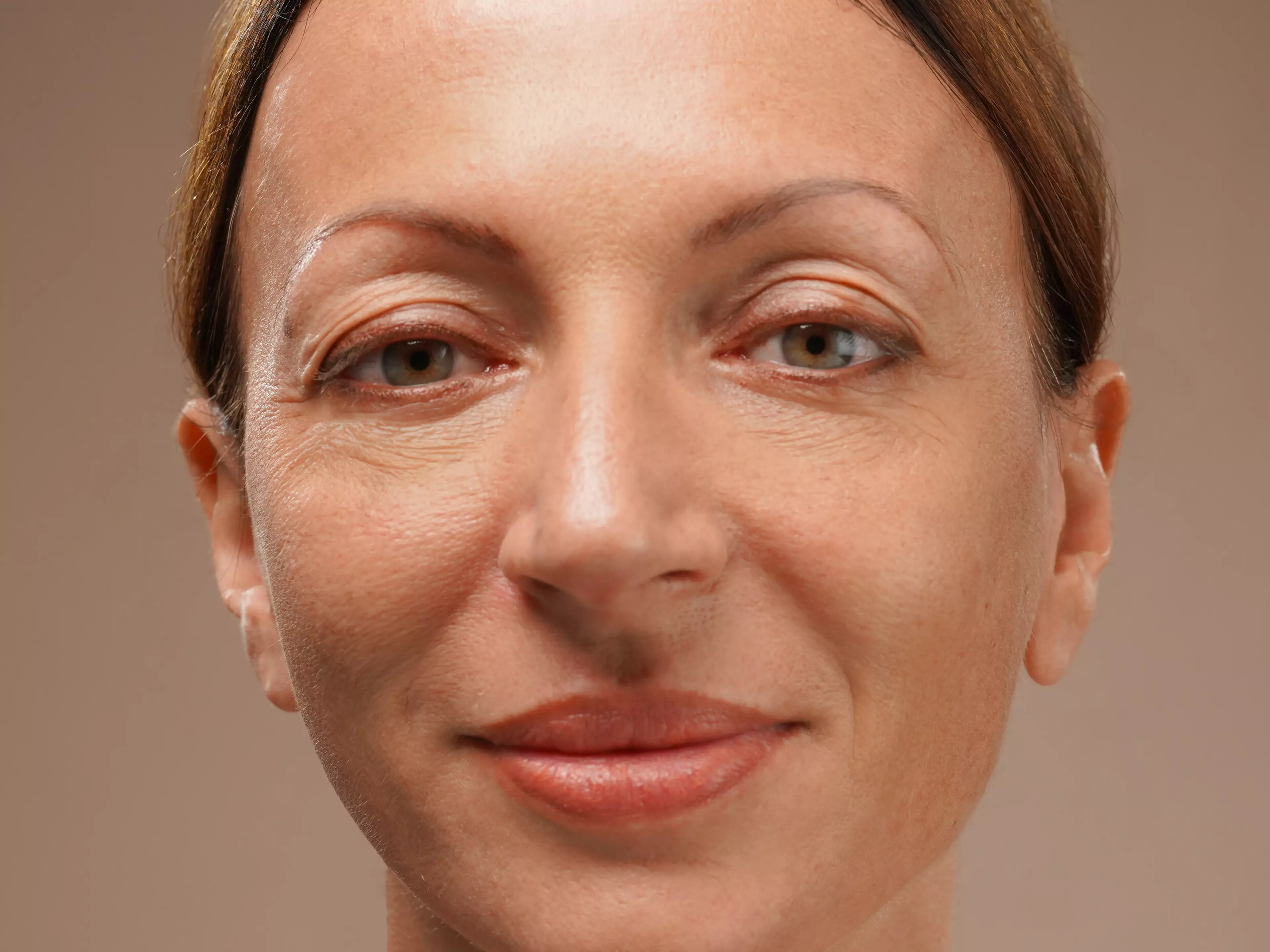A woman with glossy finish skin, looking vibrant and youthful